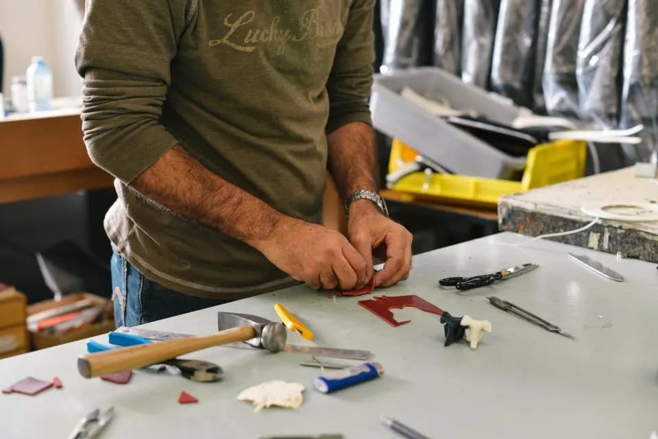 A maker checking cut components at a workbench